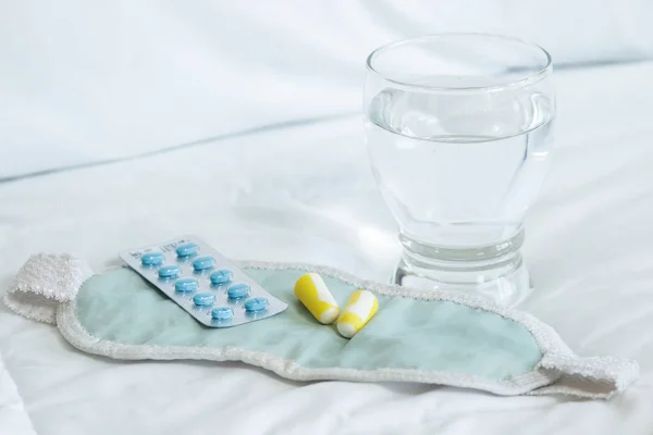 Blisterpackung mit Schlaftabletten, Augenbinde und Glas Wasser — Stockfoto