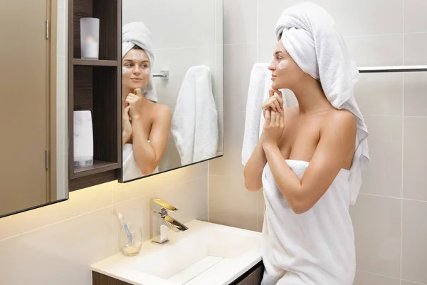 Young woman with moisturizing and anti-aging cream applied on he — Stock Photo, Image
