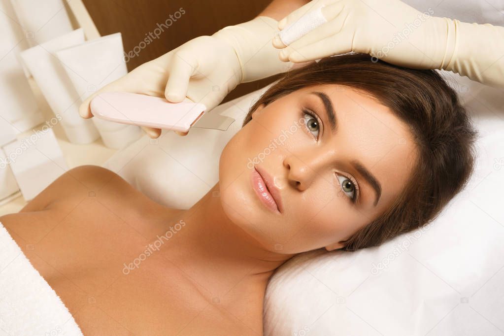 Woman during ultrasonic facial cleansing procedure