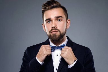 Şık yakışıklı adam papyon ile klasik bir takım giyiyor