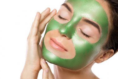 Yüzünde yeşil peeling maskesi olan kadın
