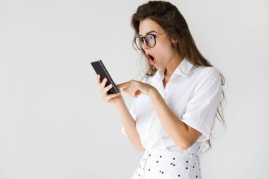 Şok yüz ifadesi ile iş kadını akıllı telefon kullanıyor