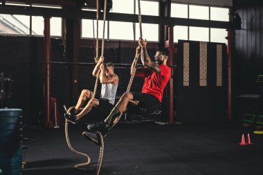 İp tırmanma egzersizi yapan iki adam