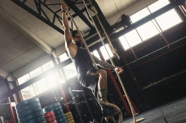 Halat tırmanma egzersizi yapan sporcu