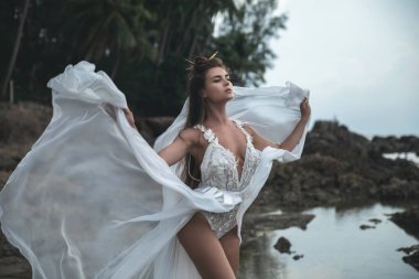 Şehvetli gelin kayalık plajda güzel gelinlik giyiyor