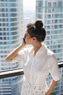 Ofisinde akıllı telefon kullanan genç iş kadını