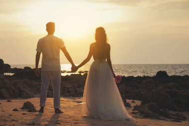 Sahilde Düğün - Genç evli çift el ele tutuşarak