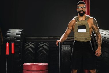 Spor salonunda yaptığı egzersiz sırasında kilo yelek giyen sporcu