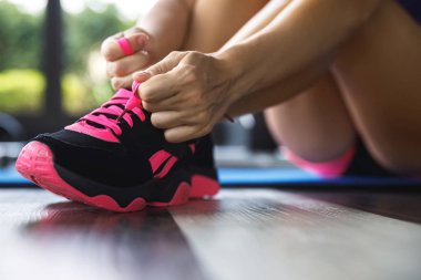 Spor ayakkabılarının ayakkabı bağcıklarını bağlayan kadın