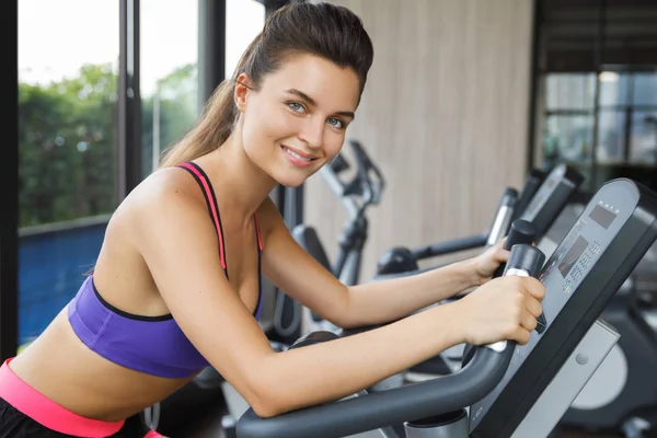 Woman on stationary bike in the gym — Stock Photo, Image