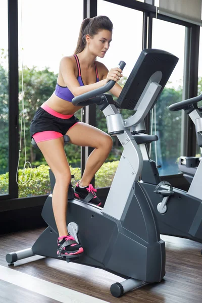 Woman on stationary bike in the gym — Stock Photo, Image