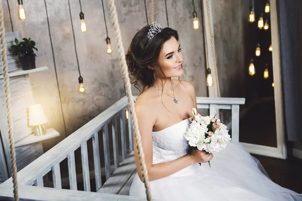 Giovane sposa felice indossa bel vestito lussureggiante in camera con — Foto Stock