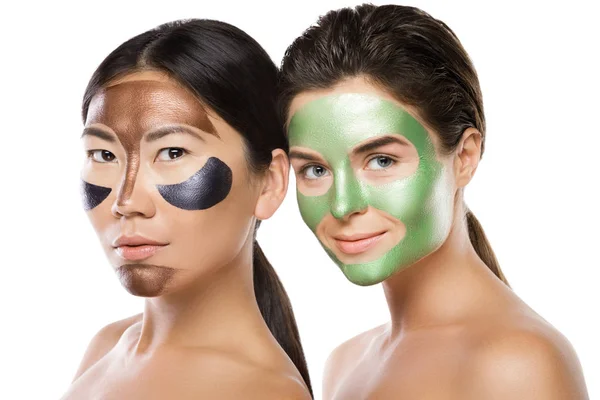 Two beautiful girls with colorful peel-off masks on their faces — Stock Photo, Image