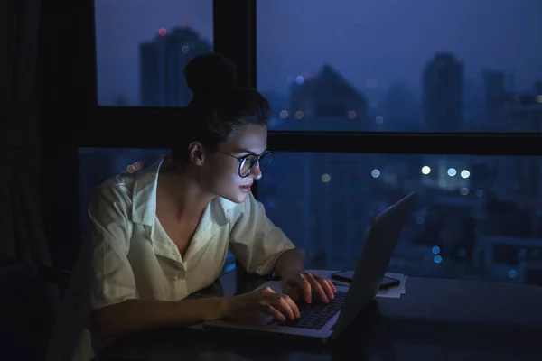 Женщина работает с ноутбуком дома ночью . — стоковое фото
