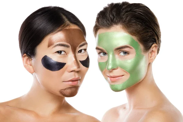 Dua gadis cantik dengan masker kulit berwarna-warni di wajah mereka — Stok Foto