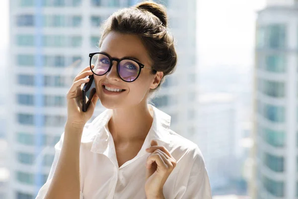 Young businesswoman using smartphone in her office — Stock Photo, Image