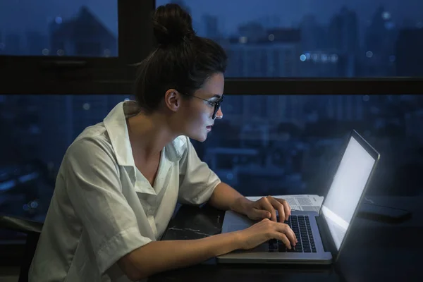 Vrouw werkt 's nachts met laptop thuis. — Stockfoto