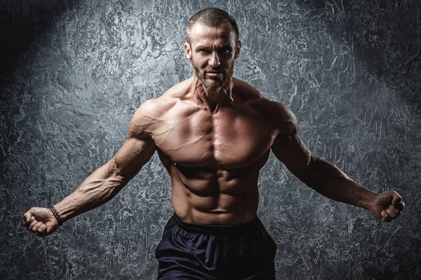 Forte e musculoso fisiculturista mostrando seu corpo — Fotografia de Stock