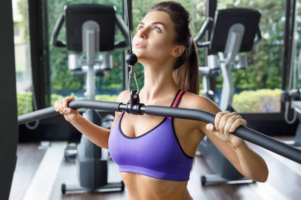 Kobieta robi ćwiczenia na plecach-lat pulldown — Zdjęcie stockowe