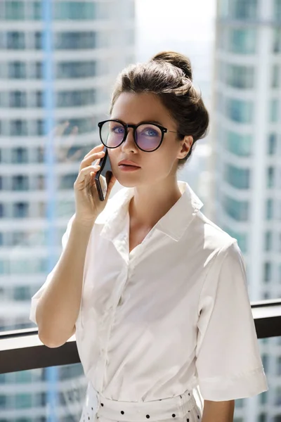 Young businesswoman using smartphone in her office — Stock Photo, Image