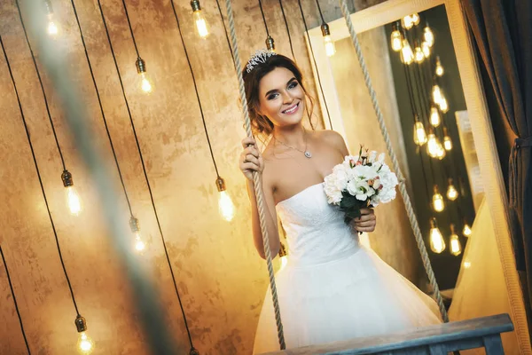 Young happy bride n the room with a lot of light bulbs — Stock Photo, Image