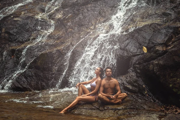 Par sitter under det kalla vattenfallet under varm dag — Stockfoto