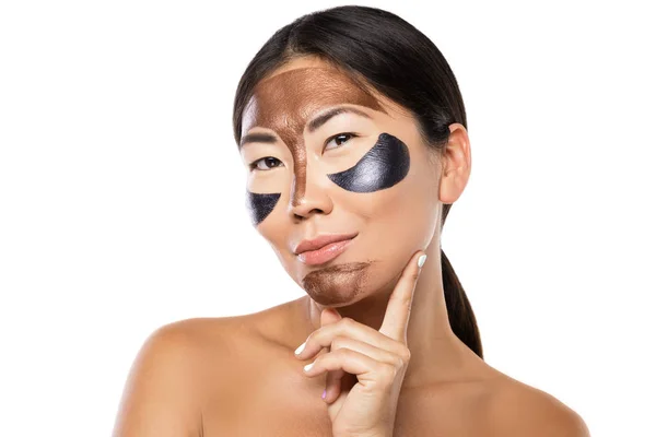 Young asian woman with a purifying peel-off mask on her face — Stock Photo, Image