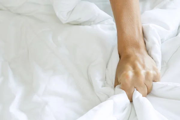 Hand squeezing bed sheet — Stock Photo, Image