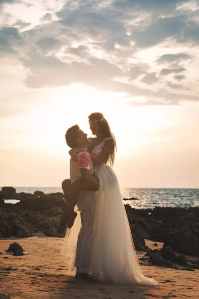 Matrimonio in spiaggia. Giovane e bella coppia sposata in embr — Foto Stock