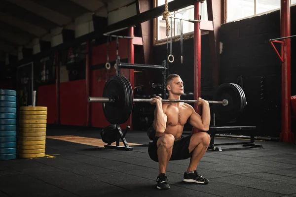 Homem musculoso durante seu exercício de levantamento de peso no ginásio — Fotografia de Stock