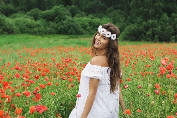 Beautiful woman in field with a lot of poppy flowers