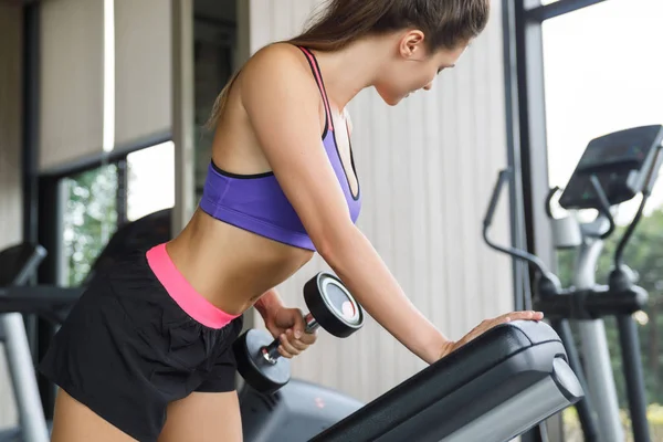 Vrouw tijdens de back workout. Een hand halter rij. — Stockfoto