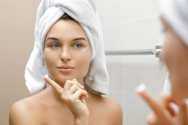 Woman using moisturizing and anti-aging cream under her eyes — Stock Photo, Image