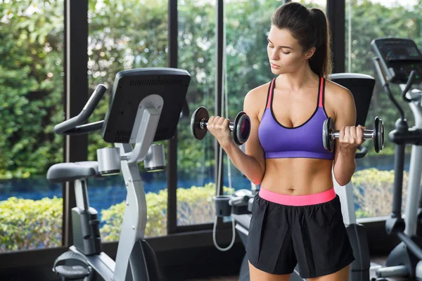 Woman working out with dumbbells in gym — Stock Photo, Image