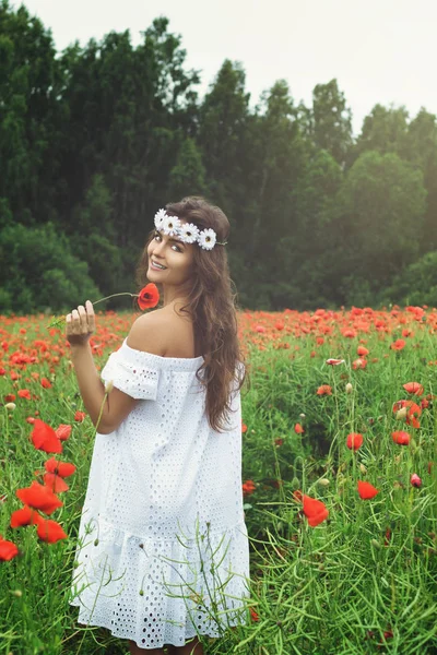 Piękna kobieta w polu z mnóstwem kwiatów maku — Zdjęcie stockowe
