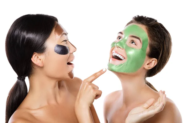 Two beautiful girls with colorful peel-off masks on their faces — Stock Photo, Image