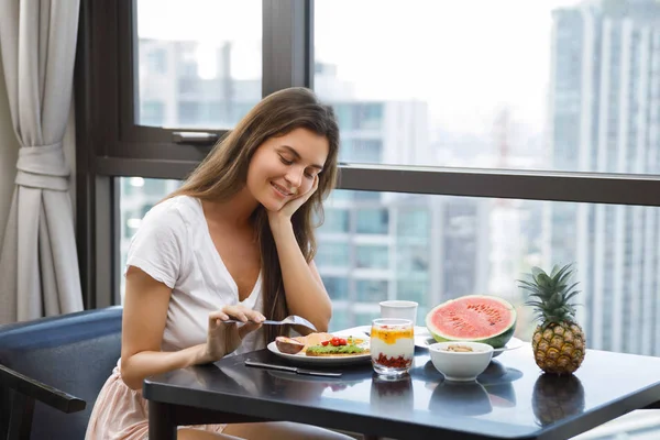 Mujer joven desayunando por la mañana —  Fotos de Stock