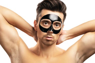Beyaz backgr yüzünde siyah kömür maskesi ile genç adam