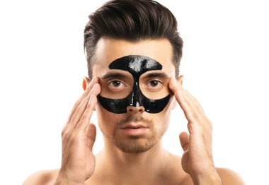 Beyaz backgr yüzünde siyah kömür maskesi ile genç adam