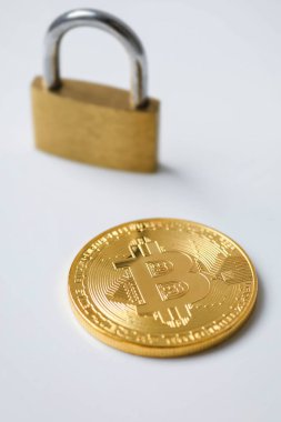 Beyaz arka planda Bitcoin ve asma kilit
