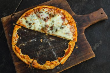 Ahşap tahta üzerinde gevrek kabuk ile lezzetli pişmiş pizza