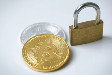 Gri arka planda Bitcoin sikkeleri ve asma kilit