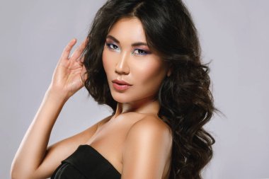 Güzel bir kıvırcık saçlı ve makyaj ile genç asya kadın