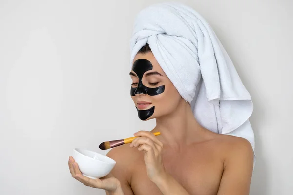 Young and beautiful woman with black peel-off mask on her face — Stock Photo, Image