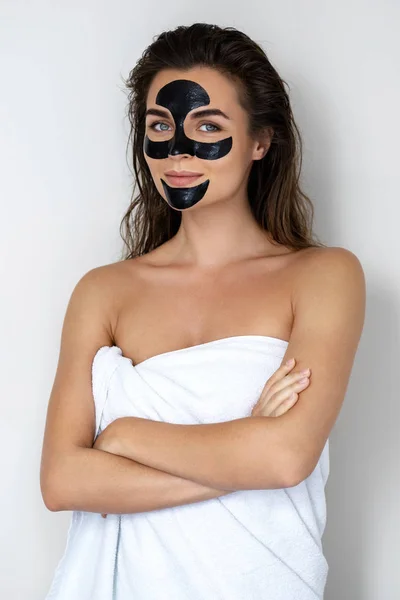 Mladá a krásná žena s černou slupkou na obličeji — Stock fotografie
