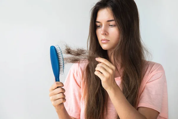 Young woman is upset because of hair loss — Stock Photo, Image