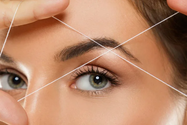 Eyebrow threading - epilation procedure for brow shape correctio — Stock Photo, Image