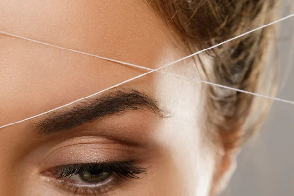 Eyebrow threading - epilation procedure for brow shape correctio — Stock Photo, Image