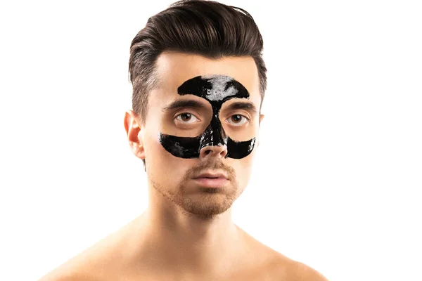 Junger Kerl mit schwarzer Kohlemaske im Gesicht auf weißem Backgr — Stockfoto