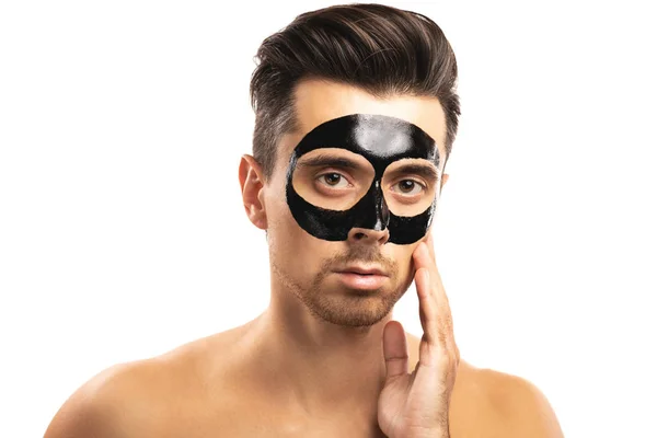 젊은 사람 와 a 검정 숯 마스크 에 그의 얼굴 에 화이트 backgr — 스톡 사진